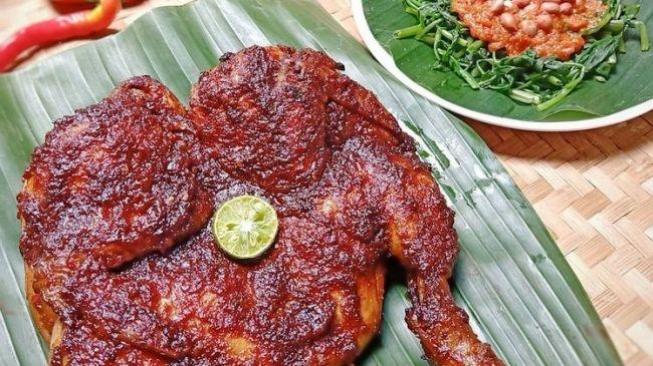 Renowned ayam taliwang from Lombok, accompanied by plecing kangkung on the right hand side [Shutterstock]