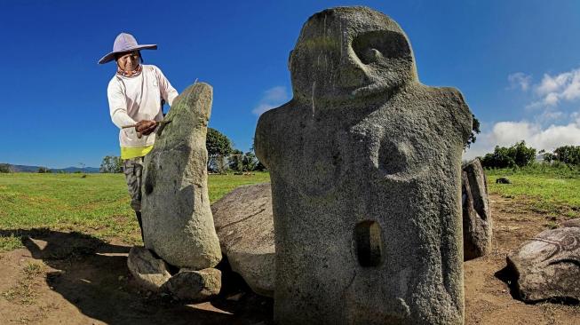 The renowned Lore Lindu megalith statues, an archaeologist does on site's work [Wikimedia Commons/Ganjarmustika1904]